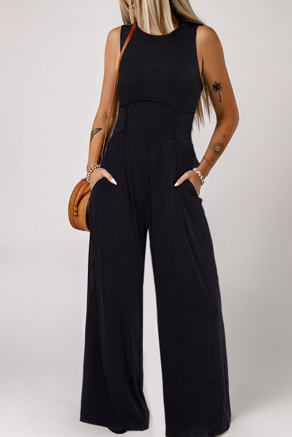 Schwarzer ärmelloser jumpsuit mit weitem bein und eingeschnürter taille