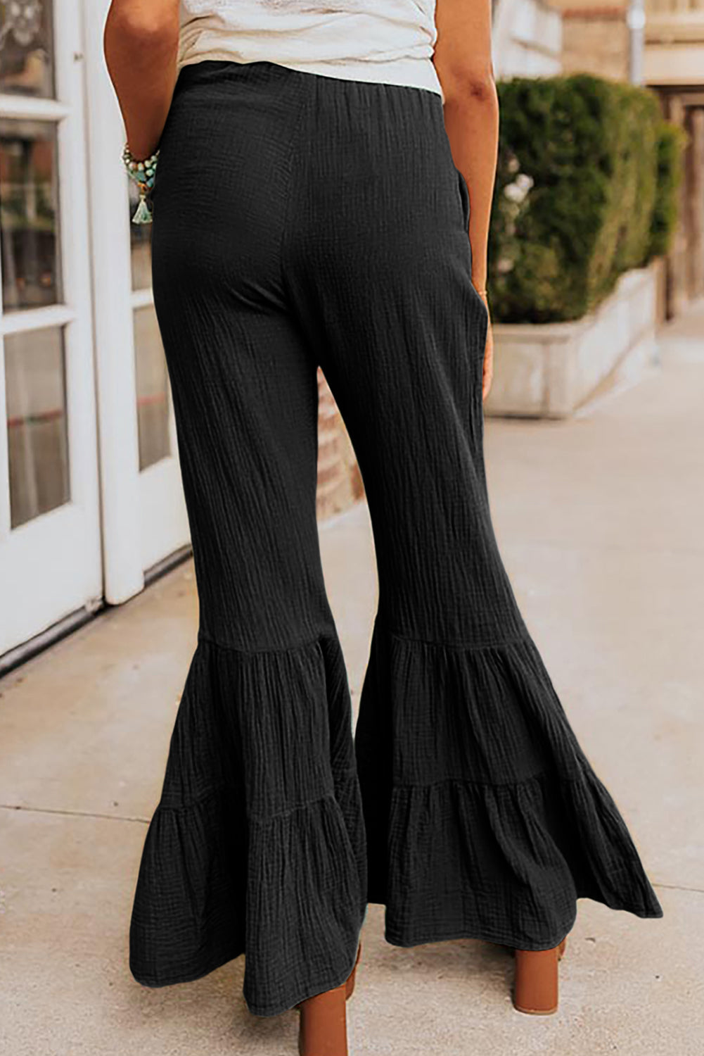 Schwarze strukturierte hose mit hoher taille und gerafftem glockenboden