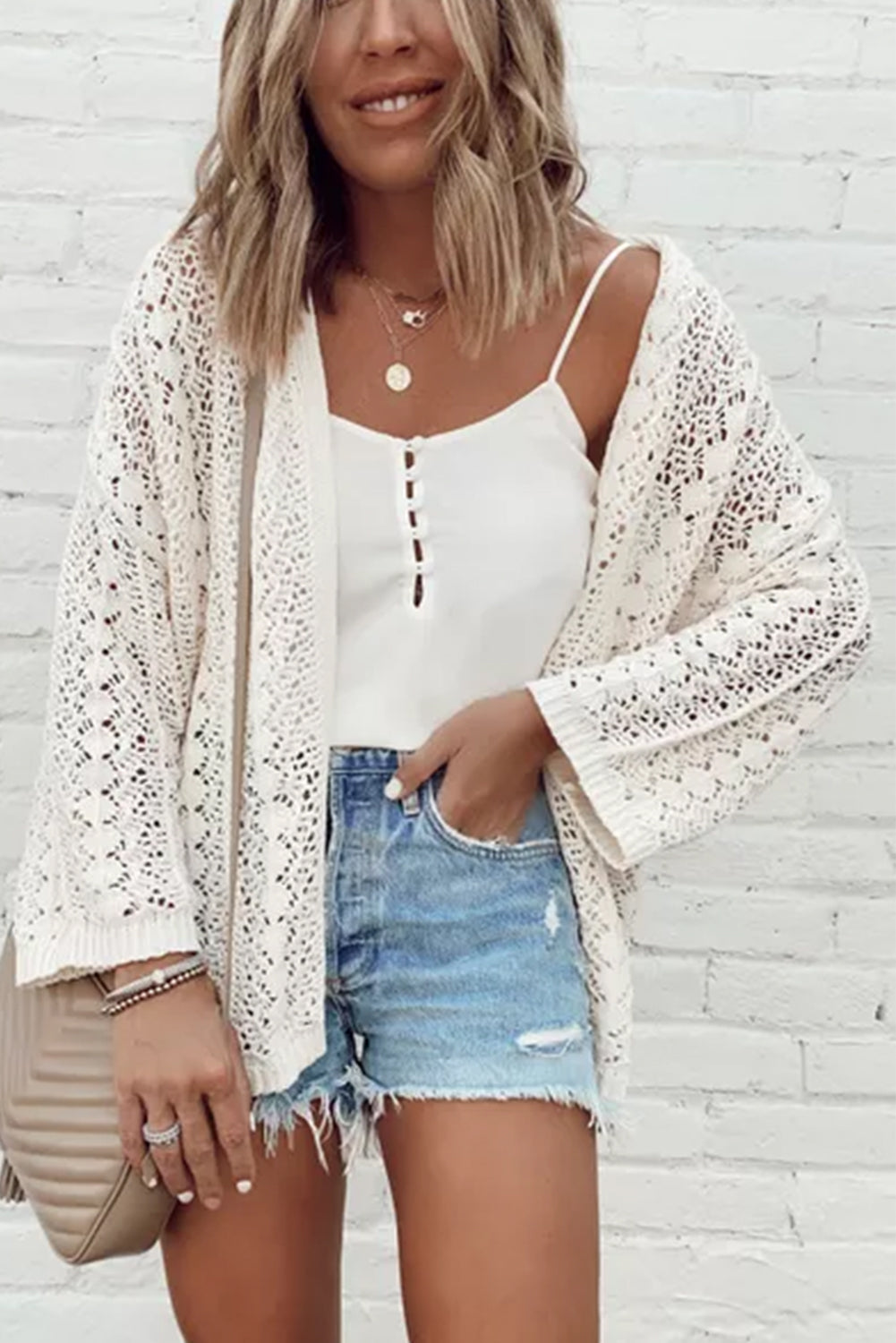 Weißer modischer strickcardigan mit hohlen schultern