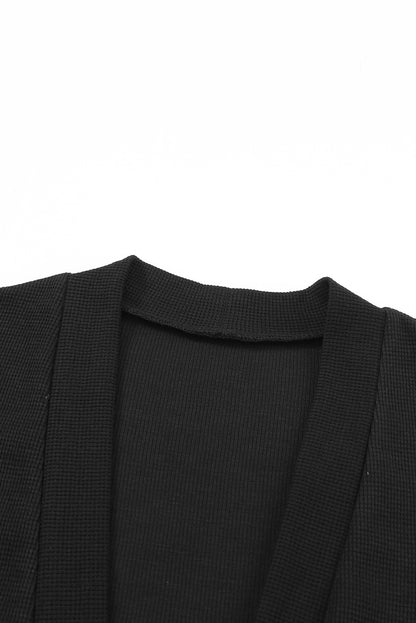 Schwarze thermo-waffelstrick-strickjacke mit taschen