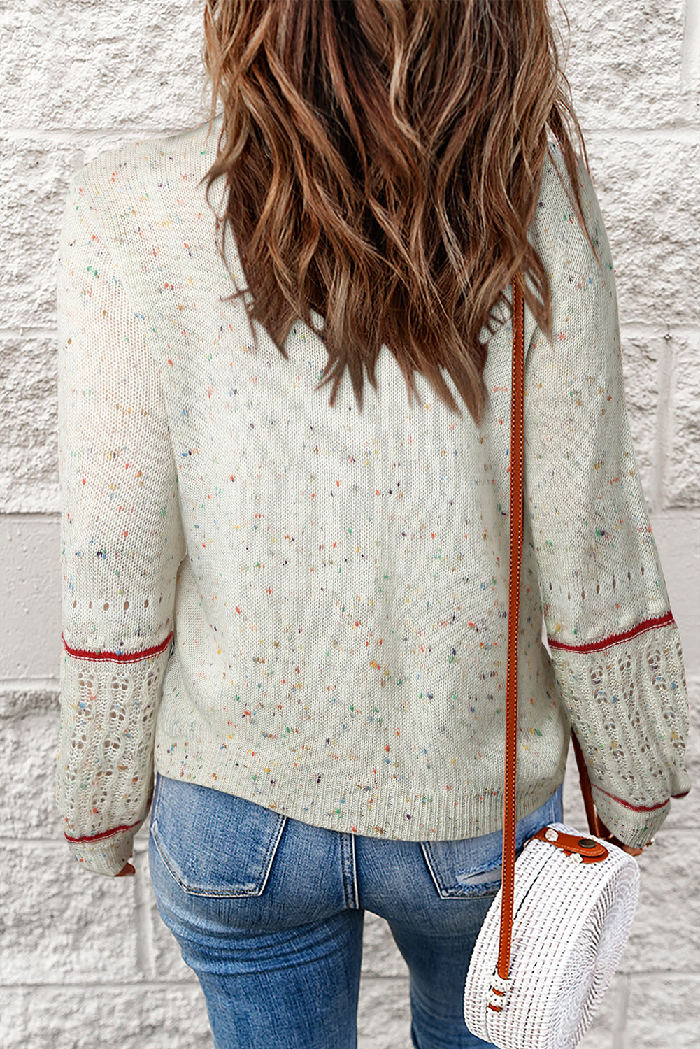 Weißer pullover mit pilling-detail und gemusterten ärmeln