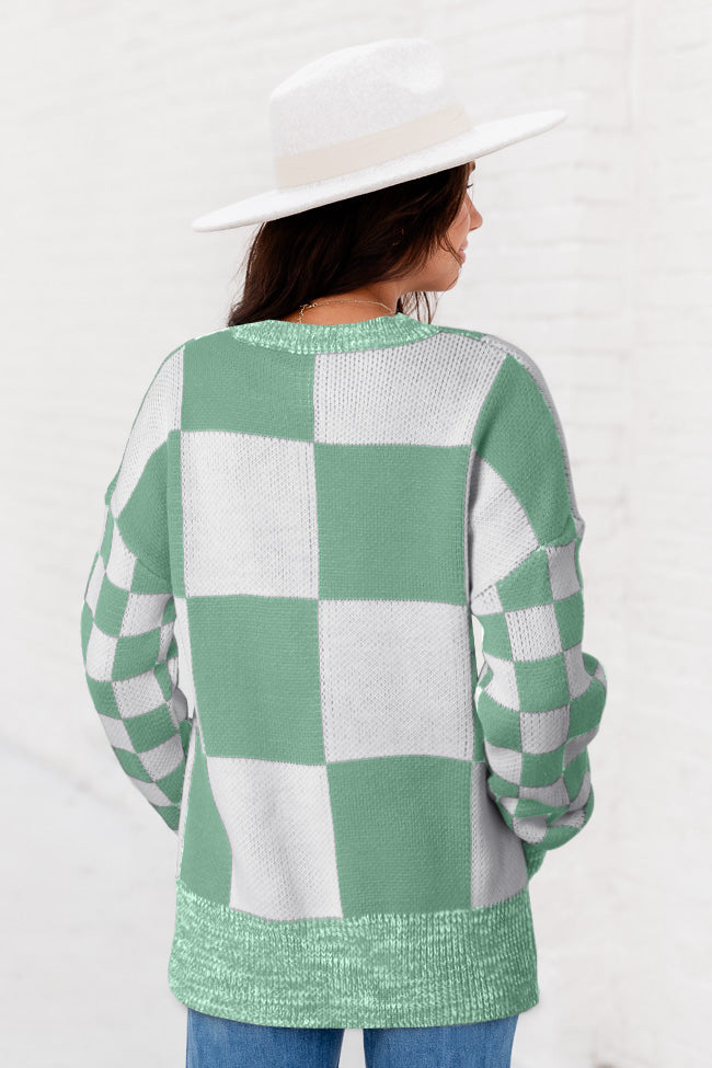 Mintgrüner pullover mit karomuster und schultertaschen